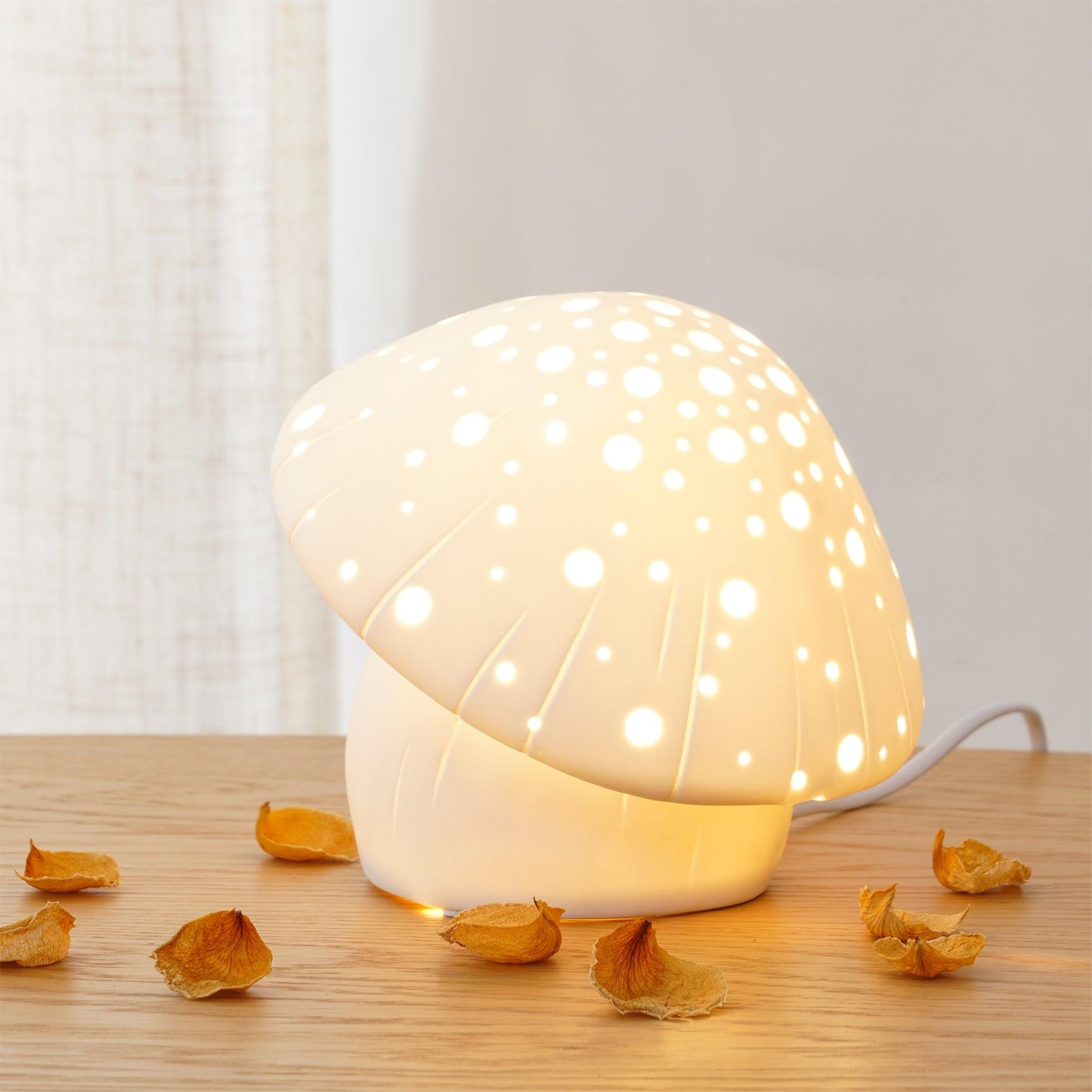 Zapalona lampa stołowa grzybowa z ozdobnymi liśćmi i tłem kurtyny