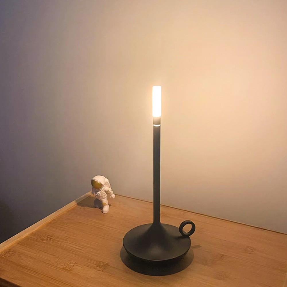 Czarna lampa S183 na drewnianym stole z blaskiem na ścianie