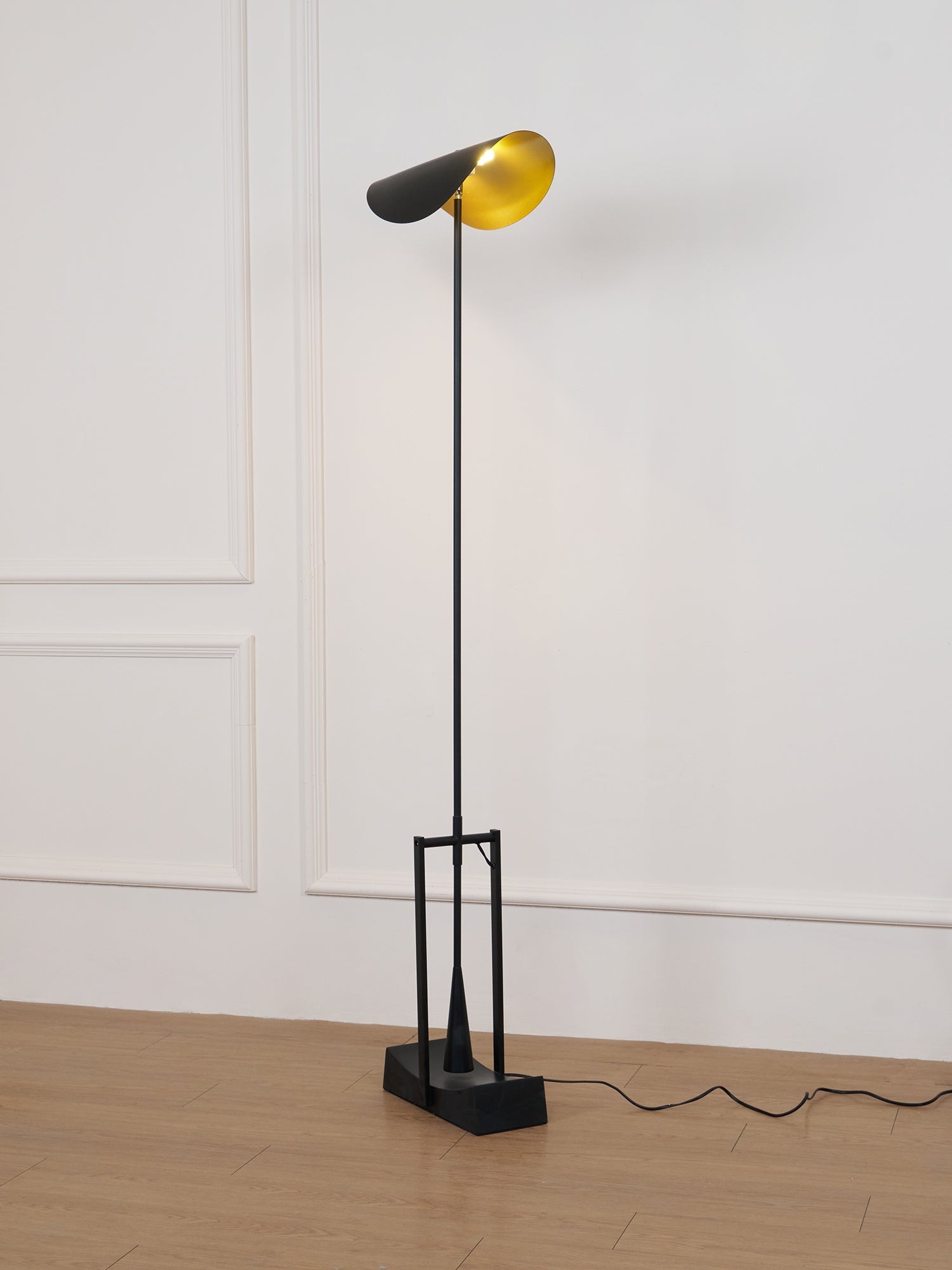 Pełna lampa podłogowa w prostym pomieszczeniu z widocznym przewodem
