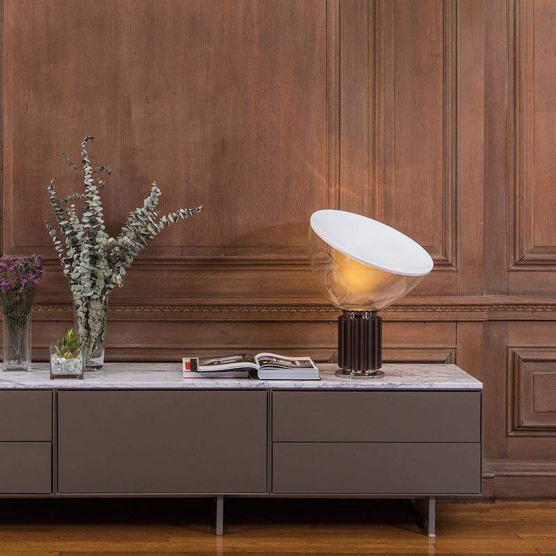 Lampa zapalona na stoliku konsolowym przy ścianie wyłożonej boazerią