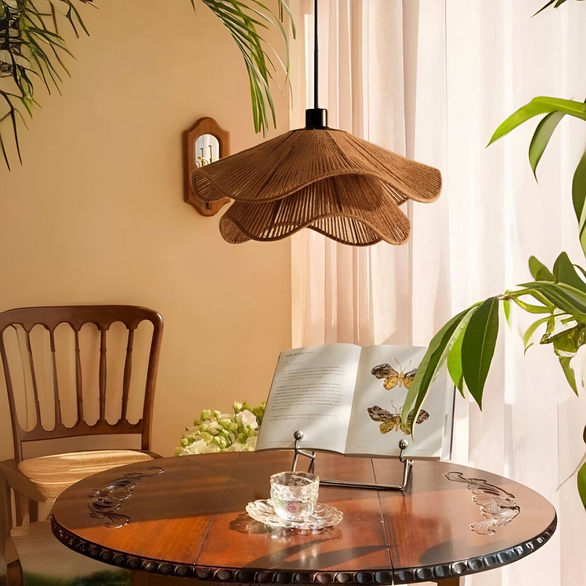 Lámpara colgante sobre una mesa redonda con plantas y decoración cálida.