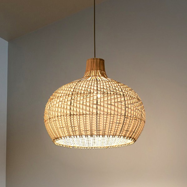 Vista ravvicinata della stanza con paralume a sospensione in rattan illuminato da una luce calda.