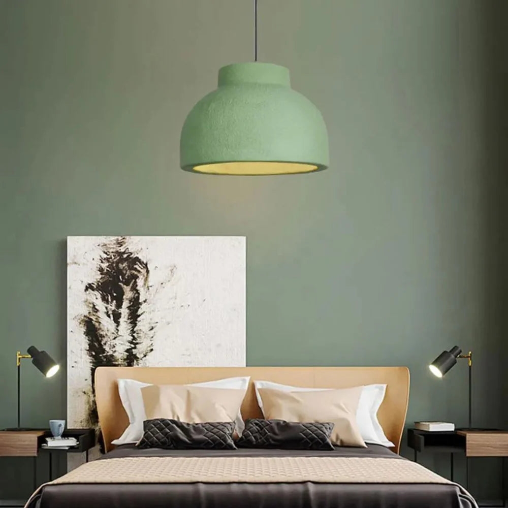Lámpara colgante verde sobre la cama