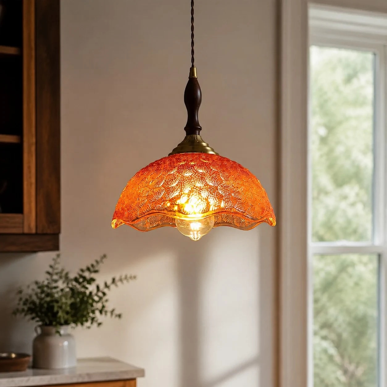 Amber glass pendant beside daylight window