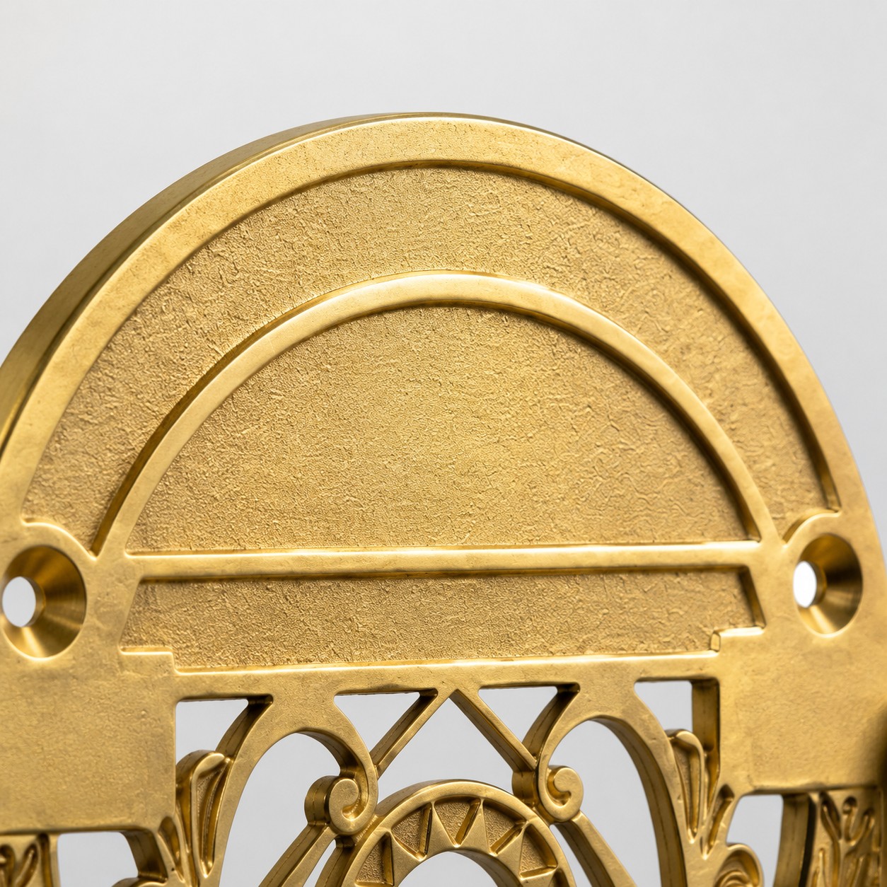 Upper brass backplate detail of the toilet paper holder
