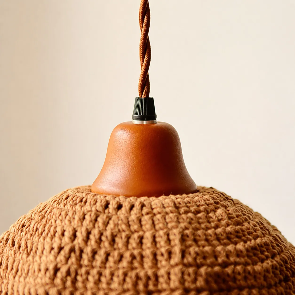 Wood lamp cup and twisted cord detail on woven pendant light