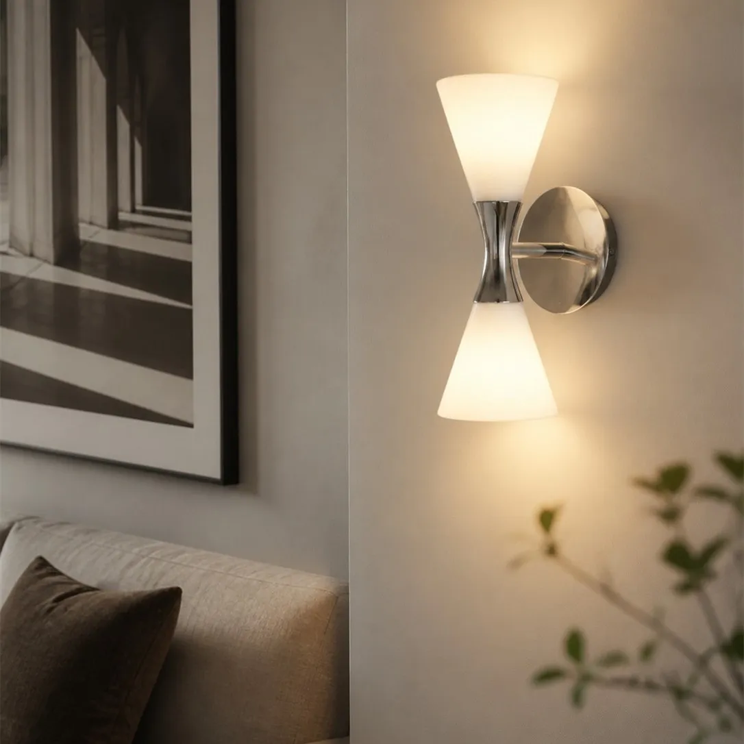 White and chrome Bauhaus wall sconce glowing on a hallway wall