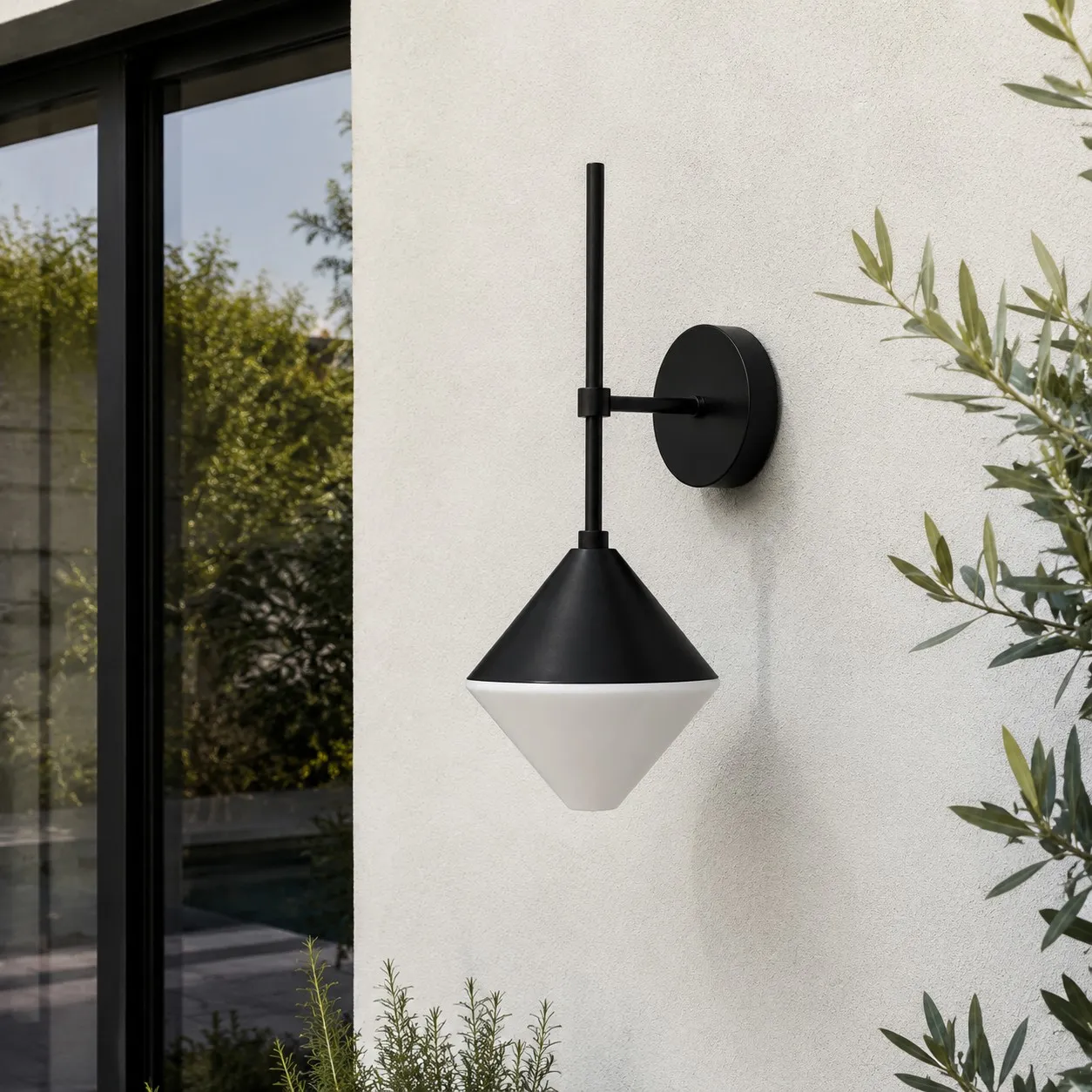 black and white outdoor wall sconce mounted on a garden exterior wall